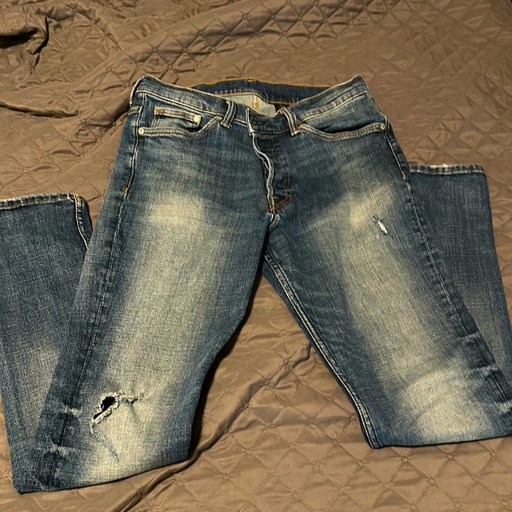 slight distress on thigh & hole in the knee. Pants are bluer than depicted